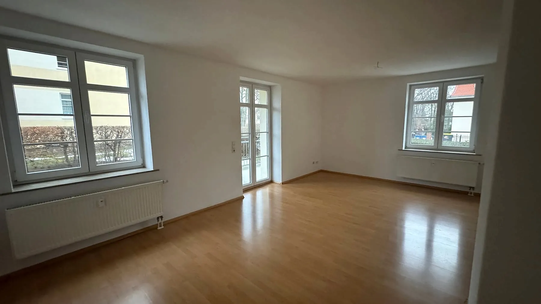 3-Zimmer-Wohnung mit Balkon, Chemnitzer Straße 49: Großes Wohnzimmer mit drei Fenstern