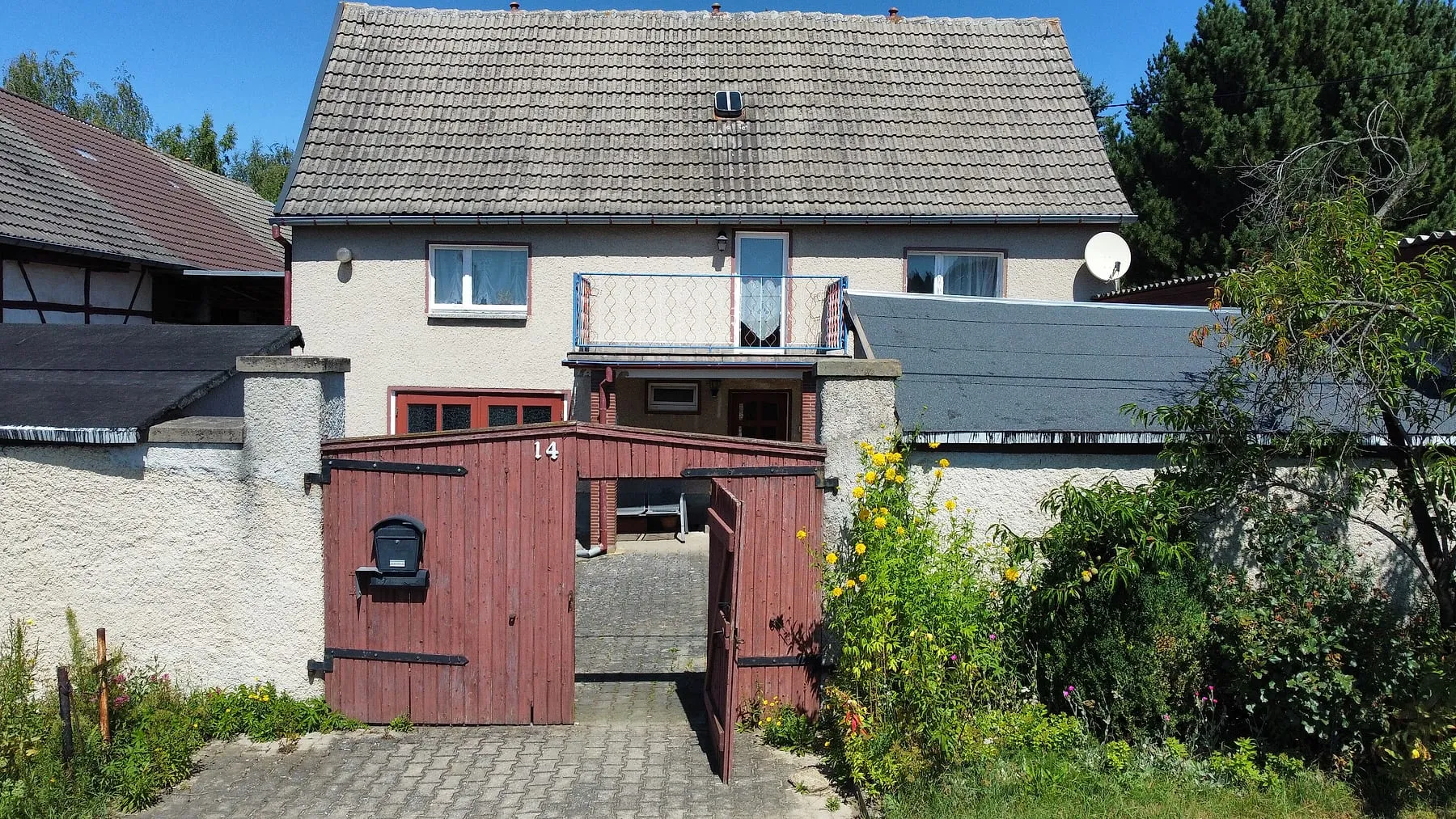 Wohnhaus mit Balkon und Hoftor von der Straße
