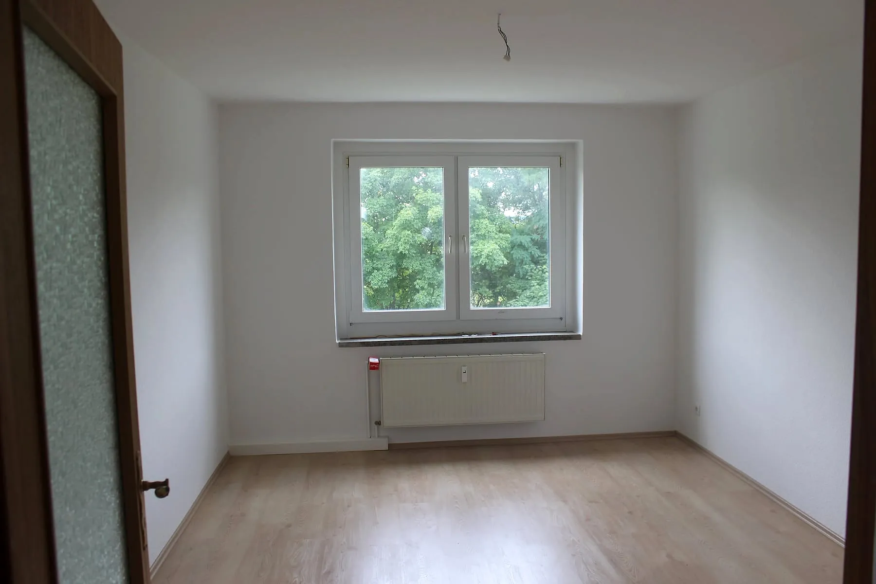 Helles Schlafzimmer mit Fenster und Feldblick