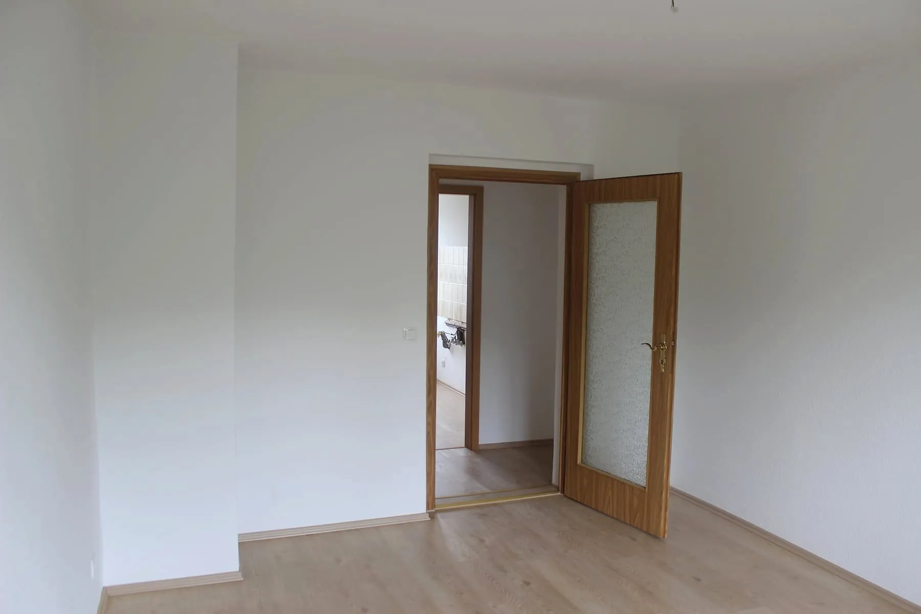 Schlafzimmer mit Laminatboden und Flügeltür