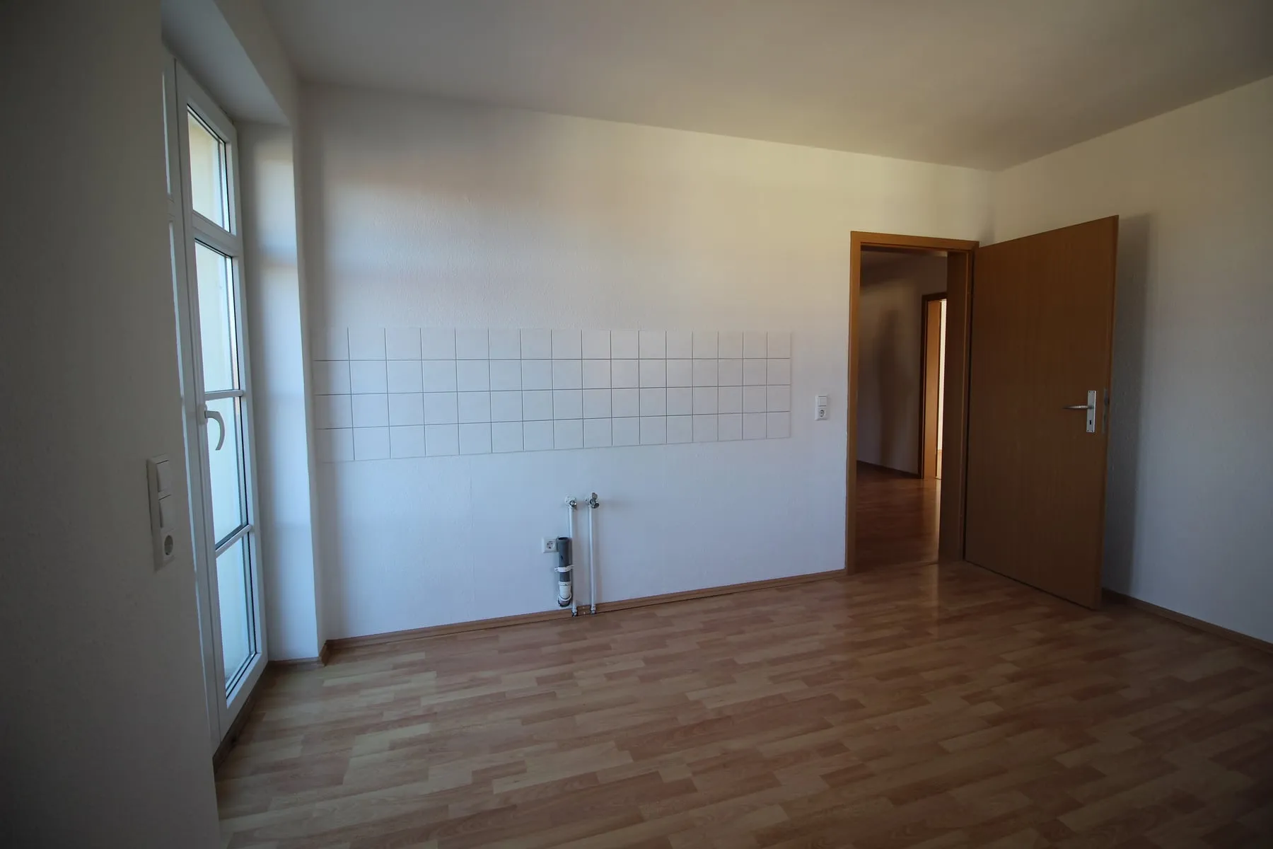 Küche mit Balkontür und Blick zum Flur