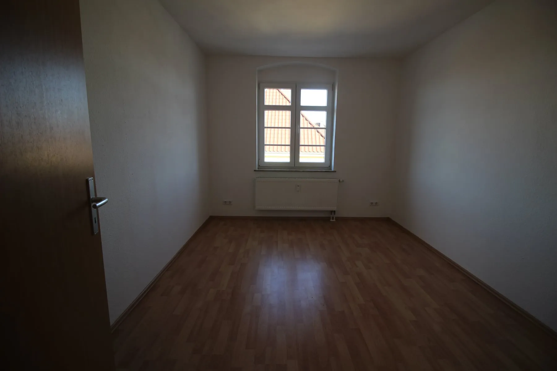 Schlafzimmer mit Fenster und Blick über die Dächer