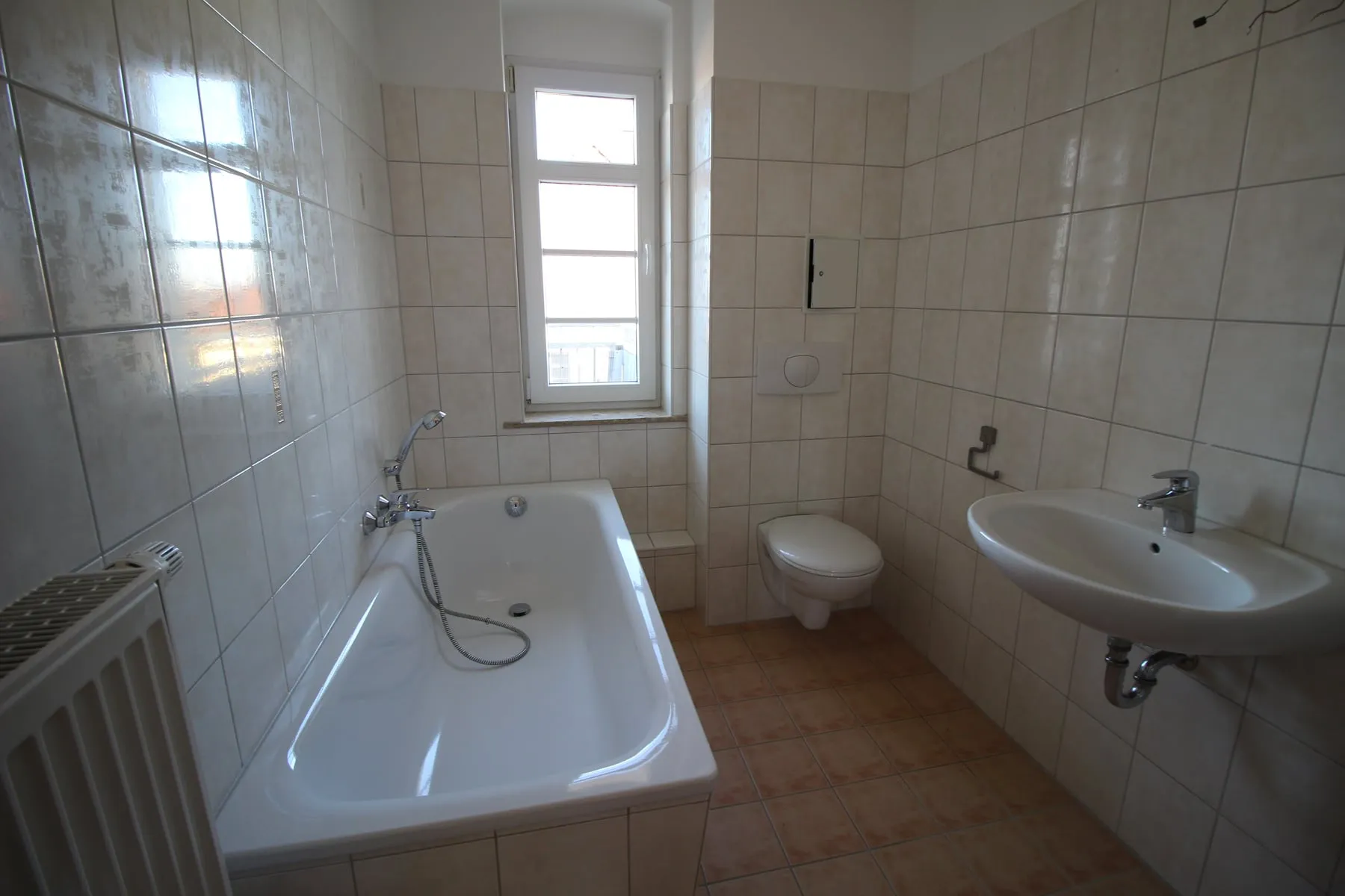 Tageslichtbad mit Badewanne, Fenster und WC