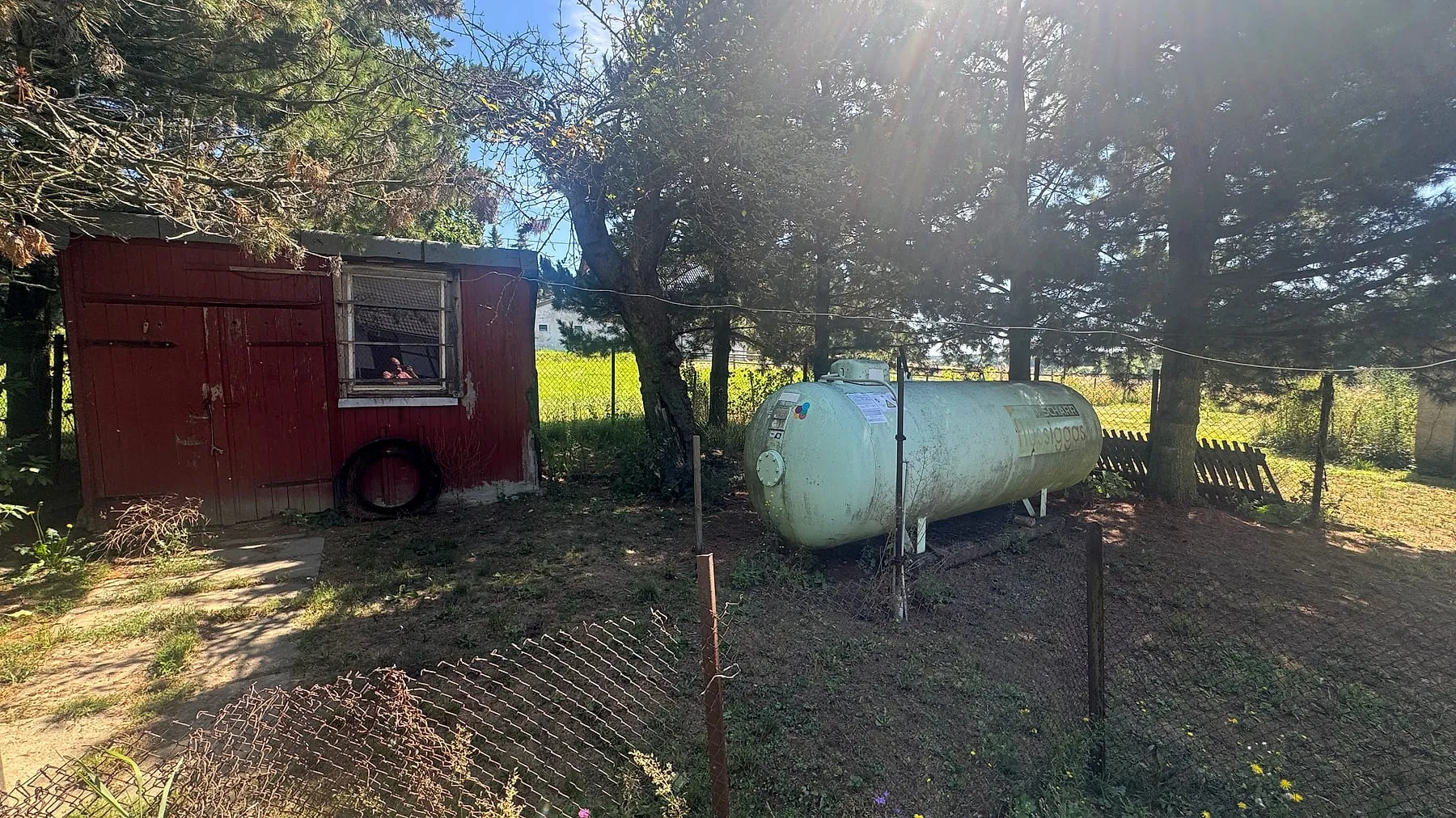 Hühnerstall und Flüssiggastank am Gartenrand
